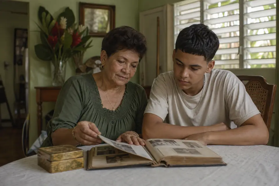 Abuela y nieto adolescente miran un álbum de fotos familiar en la mesa